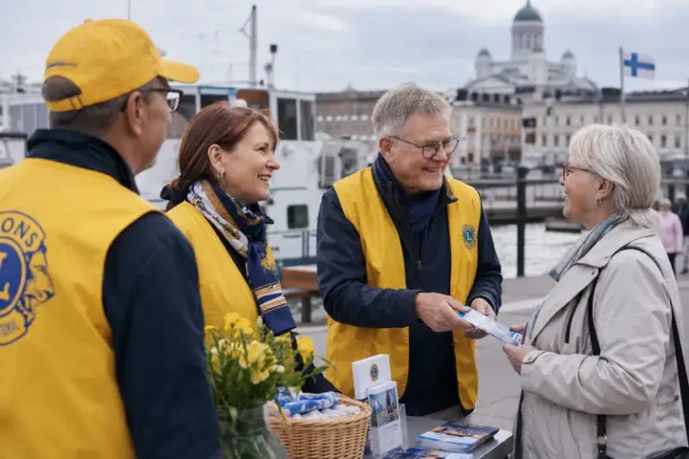LC Helsinki/Katajanokan jasenet keskustelevat ohikulkijan kanssa esittelypoydan aaressa Helsingin rannassa.