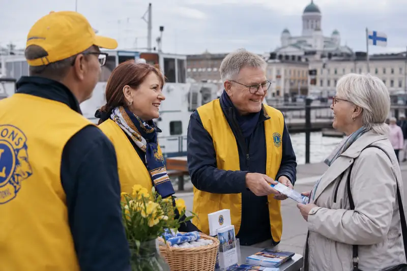 LC Helsinki/Katajanokan jasenet keskustelevat ohikulkijan kanssa esittelypoydan aaressa Helsingin rannassa.